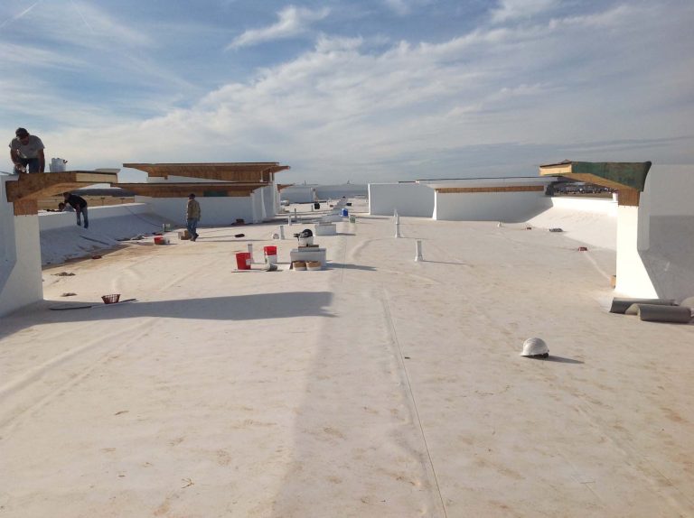 Workers are making repairs on the top of a commercial roof