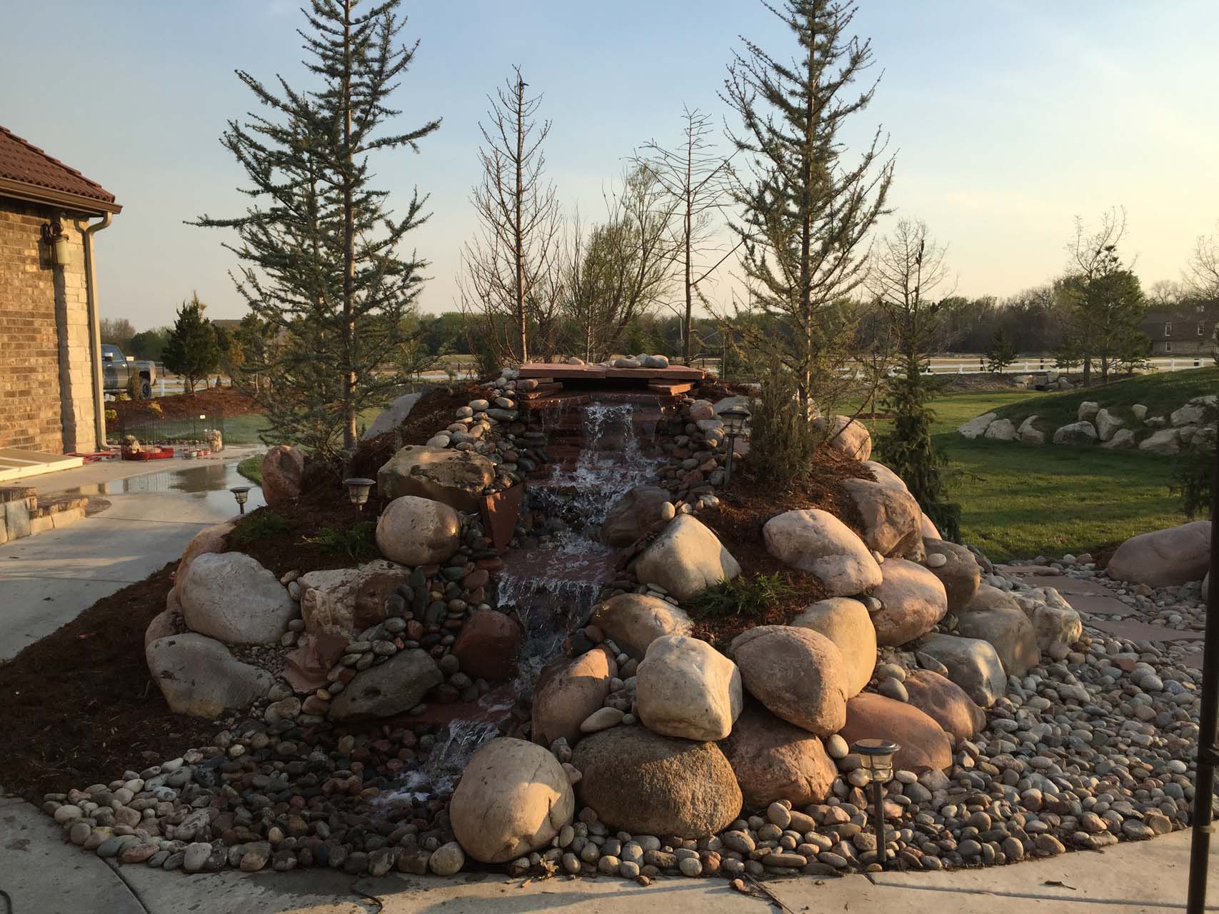 a large pile of rocks decorate an outdoor pond