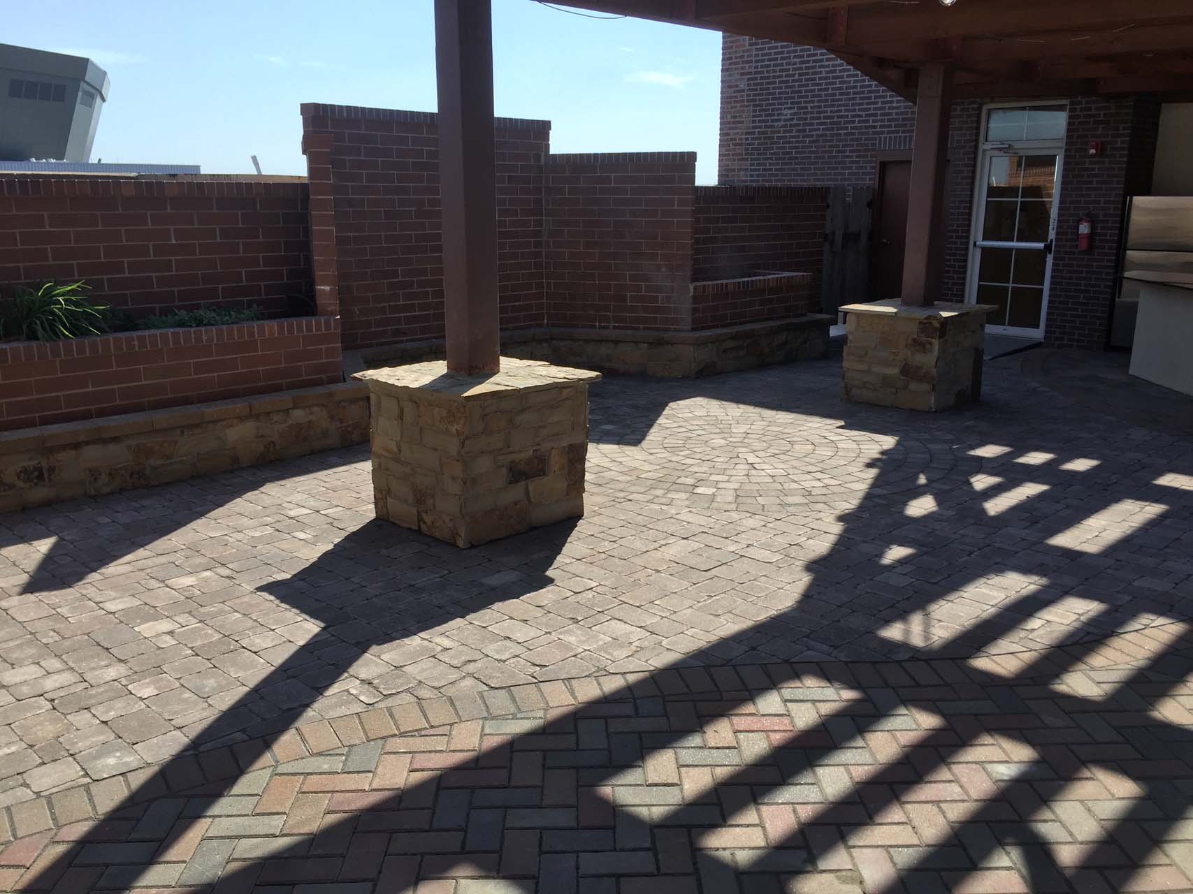 Finished outdoor space with brick patio and rock columns