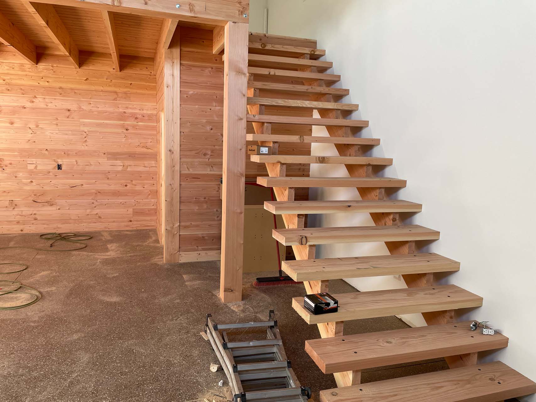 Wooden stairs lead up to a loft area