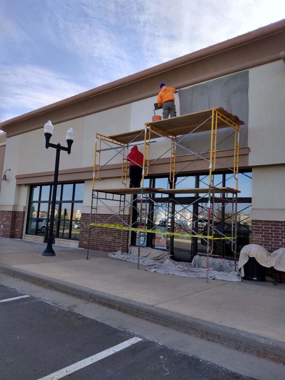 Workers apply stucco in New Market Square